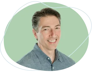 Professional portrait of mediator Joe Dillon seated at a conference table with a warm, reassuring smile, ready to guide you through an amicable divorce process. For compassionate support, call Equitable Mediation at (877) 732-6682 today.